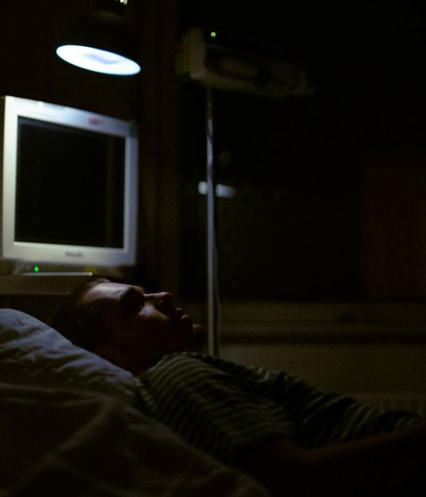Person resting peacefully in a calm, dimly lit environment.